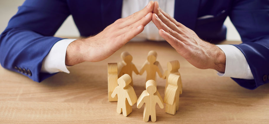 image showing a man holding hands over a group of small little wooden doll figures